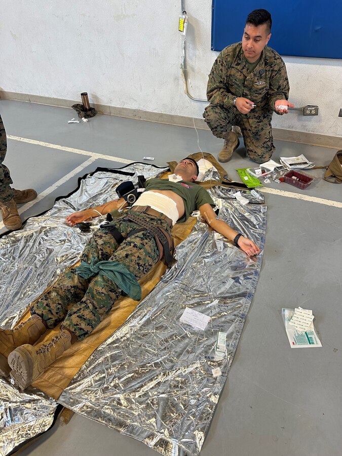 U.S. Navy Hospital Corpsman Alfredo Zuniga, 23D Marine Regiment, 4th Marine Division, Marine Forces Reserve, prepares his notional medications before administrating them to the patient, Cpl. Eric Carranza Flores for the Valkyrie whole blood transfusion program in San Bruno, CA on Jan. 10, 2024. The Valkyrie Program is a course designed to teach attendees how and when to apply a whole blood transfusion to casualties in a combat environment. (Courtesy Photo)