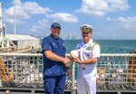 U.S. Coast Guard Capt. Justin Carter, left, the commanding officer of Coast Guard Cutter Hamilton (WMSL 753), shakes hands with U.S. Navy Capt. Dan Betancourt, right, senior defense official Panama, in Panama City, Panama, Jan. 24, 2024. Hamilton became the first U.S. government vessel to moor at the newly constructed Amador cruise terminal.
