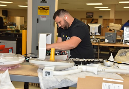 A biomedical equipment technician works on a medical device at the U.S. Army Medical Materiel Agency’s Medical Maintenance Operations Division at Hill Air Force Base, Utah. (C.J. Lovelace)