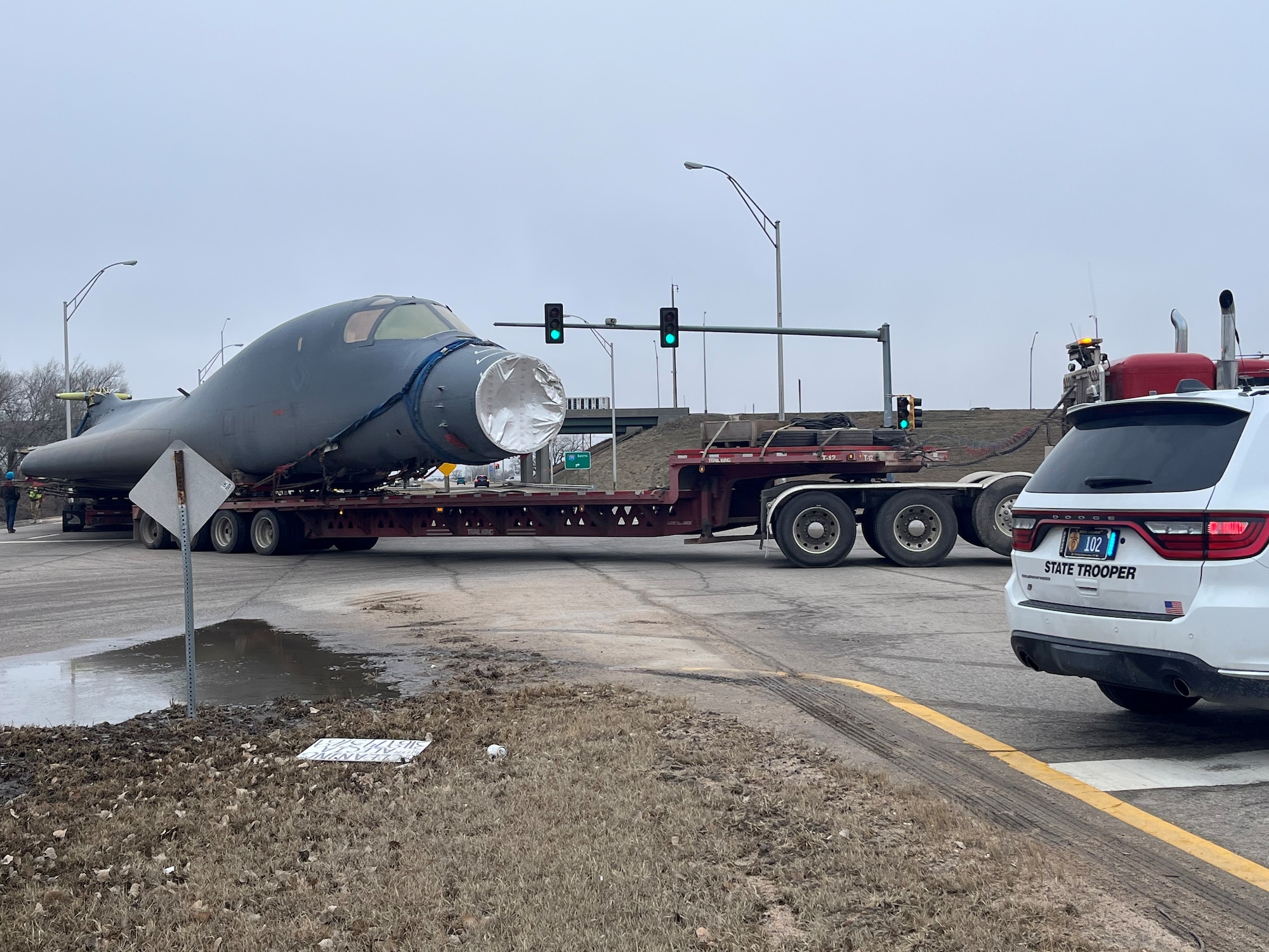Drivers navigate a B-1B Lancer around obstructions enroute to Wichita State University’s National Institute for Aviation Research as part of a research partnership in Wichita, Kansas, Jan. 27, 2024. B-1s are not unfamiliar to longtime local residents, although this type of low-level approach is a rarity. The Kansas Air National Guard’s current 184th Wing operated B-1s from McConnell Air Force Base when it was the 184th Bomb Group, starting in July 1994. The 184th Bomb Group became the 184th Bomb Wing in 1995 and flew the B-1s until June 2001.  (Courtesy Photo)