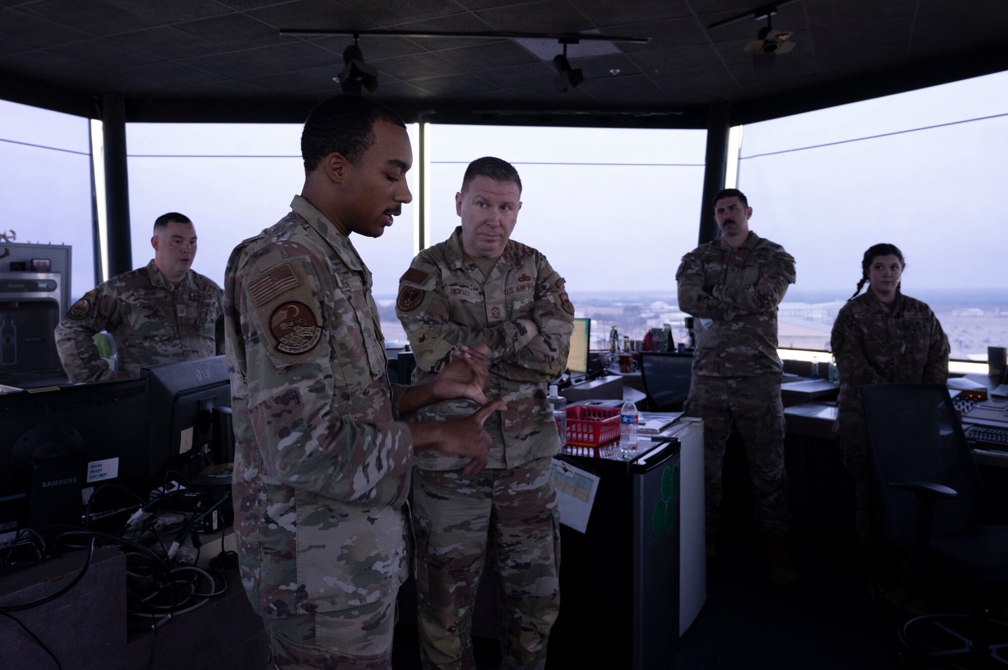 U.S. Air Force Chief Master Sgt. Chad Bickley (middle), command chief for Air Education and Training Command, speaks with Airman 1st Class Stephen Austin (left), 47th Operations Support Squadron air traffic controller, about the operations of the air traffic control tower at Laughlin Air Force Base, Texas, Jan. 22, 2024. Bickley visited Laughlin’s Airmen at the tower and learned more about daily operations and how they are supporting Laughlin’s mission of producing combat-ready Airmen, leaders and pilots. (U.S. Air Force photo by Senior Airman Kailee Reynolds)
