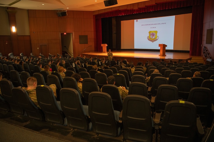 A photo of an Airman briefing a group of people.