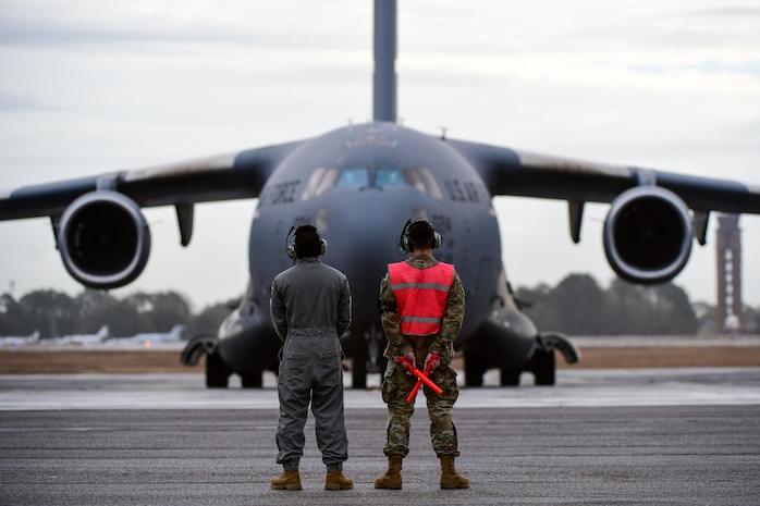A photo of Airmen preparing to marshal a jet.