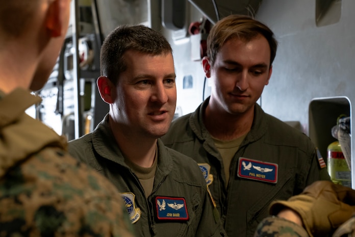 A photo of a Airmen and Marines talking.
