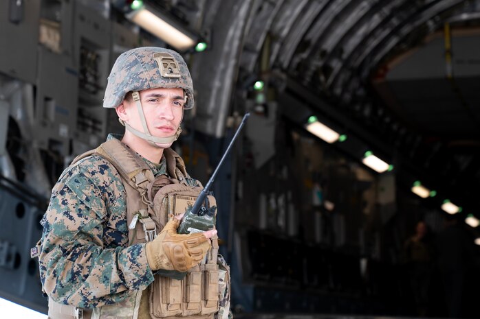 A photo of a Marine communicating through a radio.