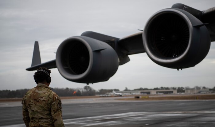 A photo of an Airman looking a the engines of an aircraft.