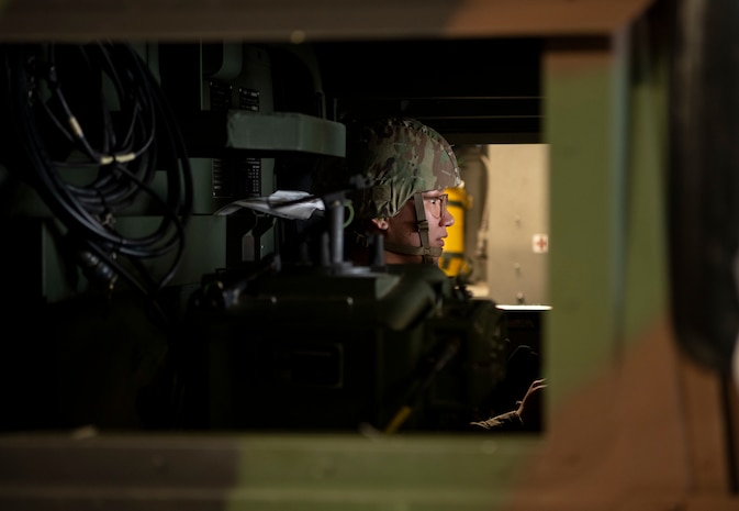 A photo of an Airman siting in a vehicle inside an aircraft.