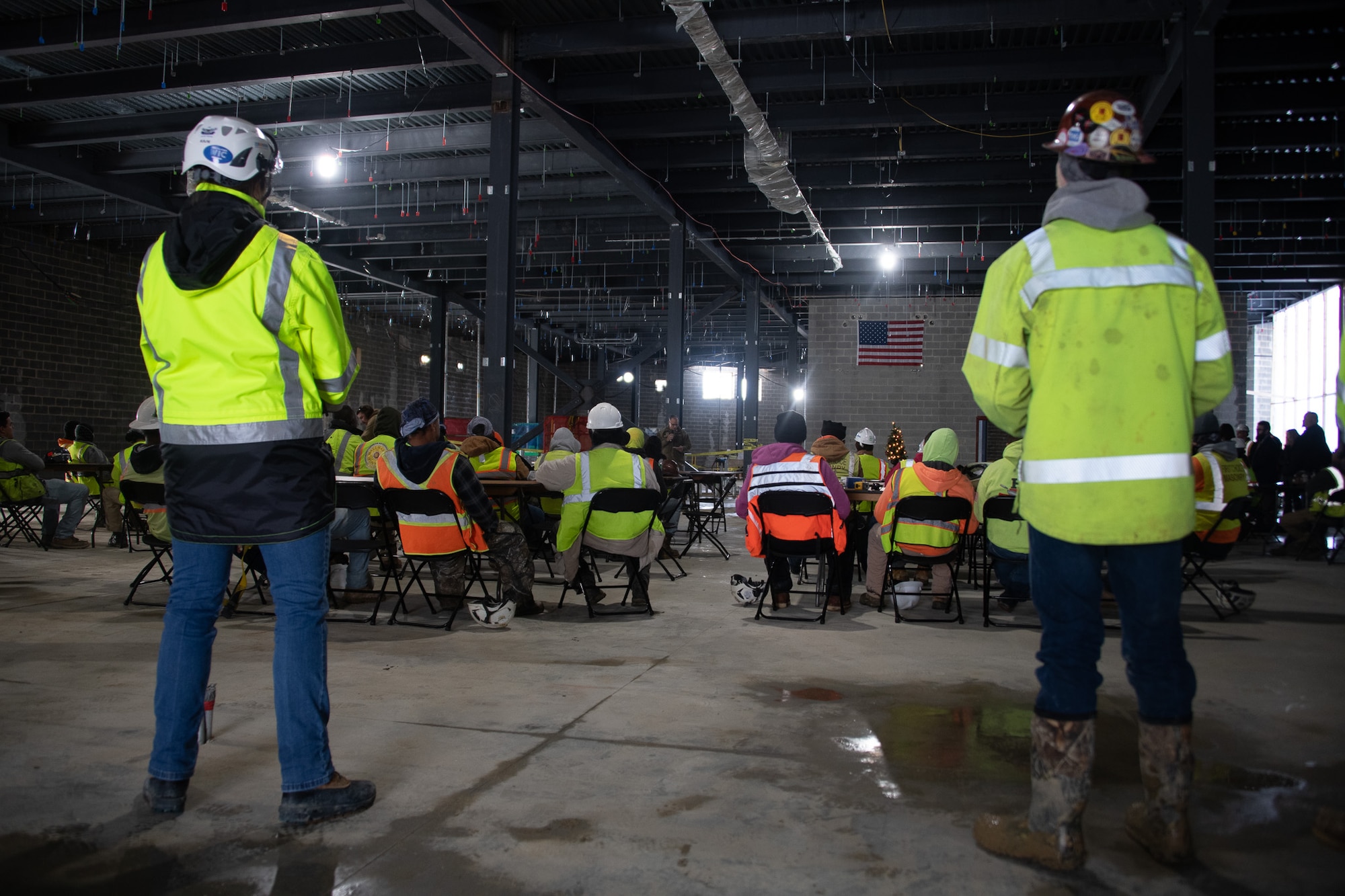Construction workers stand in interior construction site