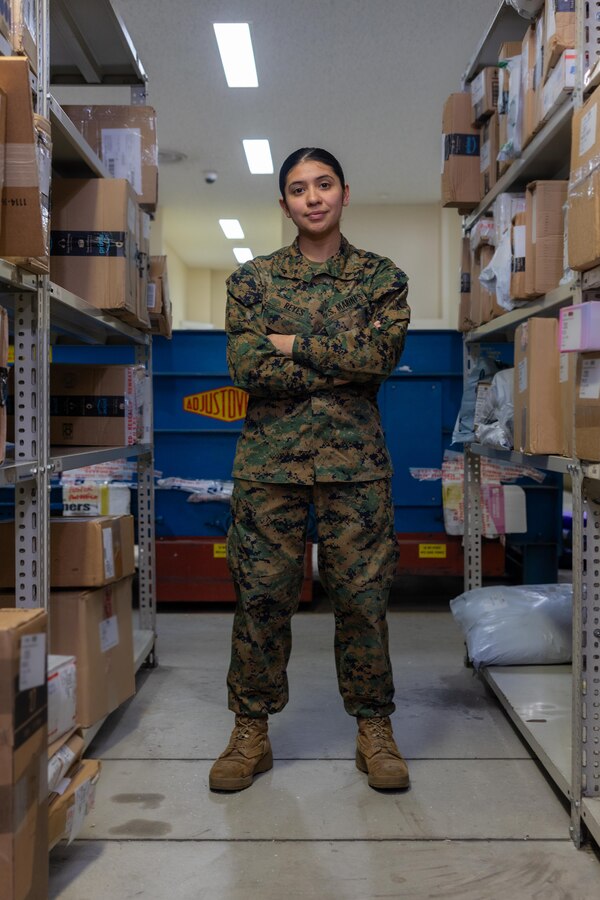 U.S. Marine Corps Lance Cpl. Ericka ValenciaReyes, a postal clerk with Headquarters and Support Battalion, Marine Corps Installations Pacific-Marine Corps Base Camp Butler, poses at the Camp Foster Post Office, on Okinawa, Japan, Jan. 10, 2024. At 9-years-old, ValenciaReyes left her hometown in N.C. for Mexico with her mother after her parents’ divorce. She decided to move back to the states and join the Marine Corps when she turned 18. Despite fracturing her pelvic bone in boot camp, she persevered and went on to graduate from Papa Company in Feb. 2021. She moved to Okinawa in July, 2022. (U.S. Marine Corps photo by Cpl. Martha Linares)