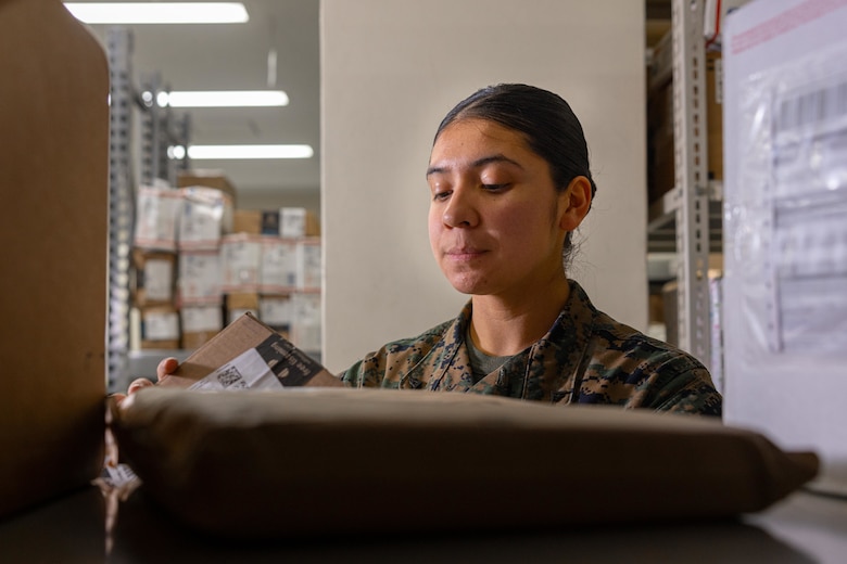 U.S. Marine Corps Lance Cpl. Ericka ValenciaReyes, a postal clerk with Headquarters and Support Battalion, Marine Corps Installations Pacific-Marine Corps Base Camp Butler, checks the mail at the Camp Foster Post Office on Okinawa, Japan, Jan. 10, 2024. At 9-years-old, ValenciaReyes left her hometown in N.C. for Mexico with her mother after her parents’ divorce. She decided to move back to the states and join the Marine Corps when she turned 18. Despite fracturing her pelvic bone in boot camp, she persevered and went on to graduate from Papa Company in Feb. 2021. She moved to Okinawa in July, 2022. (U.S. Marine Corps photo by Cpl. Martha Linares)