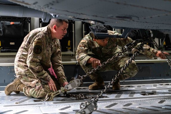 Two HH-60 avionics Airmen offload an HH-60W.