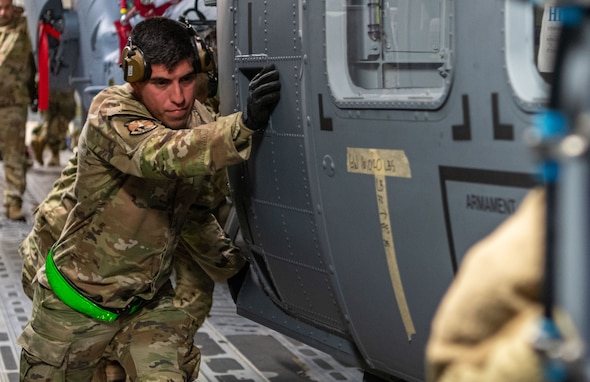 An HH-60 avionics apprentice offloads an HH-60W from a C-17.