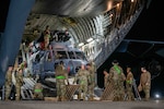 An HH-60W Jolly Green II sits inside of a C-17.