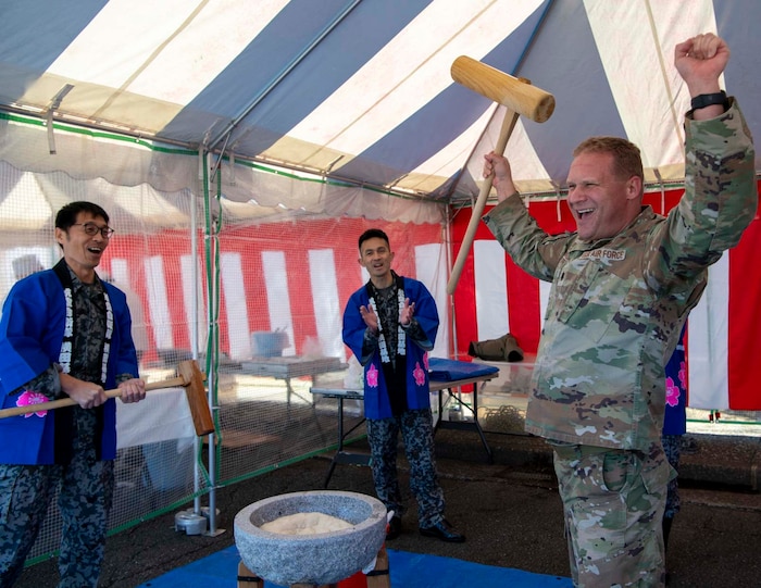 An Airman celebrates after pounding mochi.