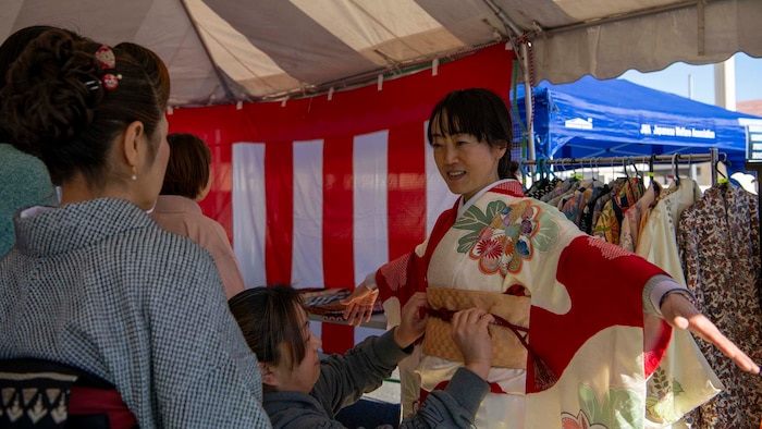 A person tries on kimonos.