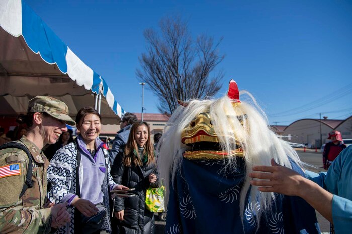 A performer dressed as a lion greets people.