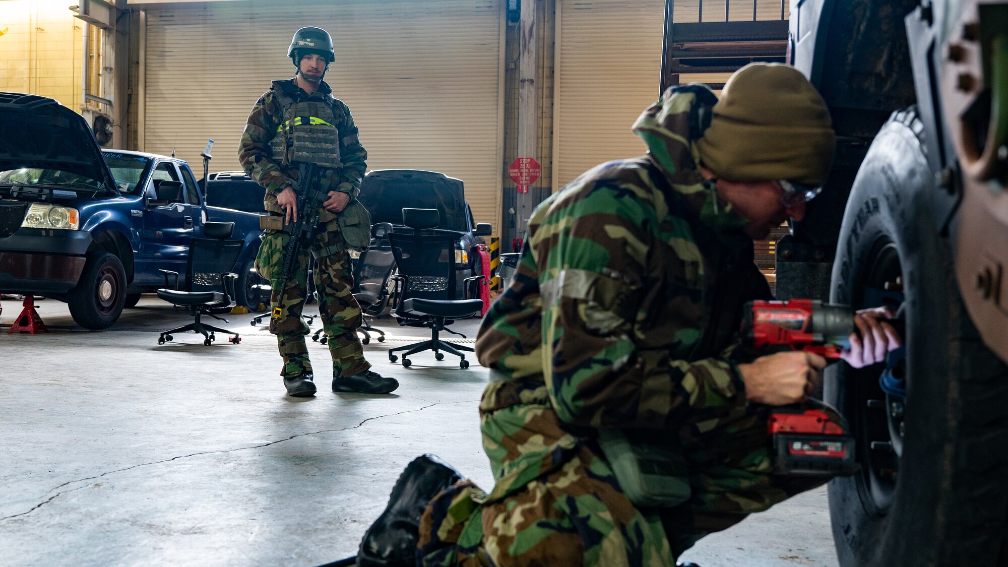 Senior Airman Jacques Trocchio, right, changes a tire as Airman 1st Class Joshua Bauman stands guard during Beverly Midnight 24-1.