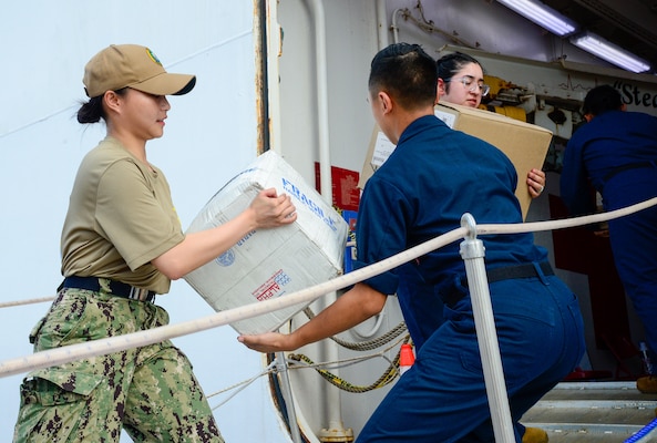 U.S. Navy Sailors participate in a working party to onload mail onto the hospital ship USNS Mercy (T-AH 19) during Pacific Partnership 2024-1 while anchored off Honiara, Solomon Islands, Dec. 1, 2023. Pacific Partnership, now in its 19th iteration, is the largest multinational humanitarian assistance and disaster relief preparedness mission conducted in the Indo-Pacific and works to enhance regional interoperability and disaster response capabilities, increase security stability in the region, and foster new and enduring friendships. (U.S. Navy photo by Mass Communication Specialist 2nd Class Celia Martin)