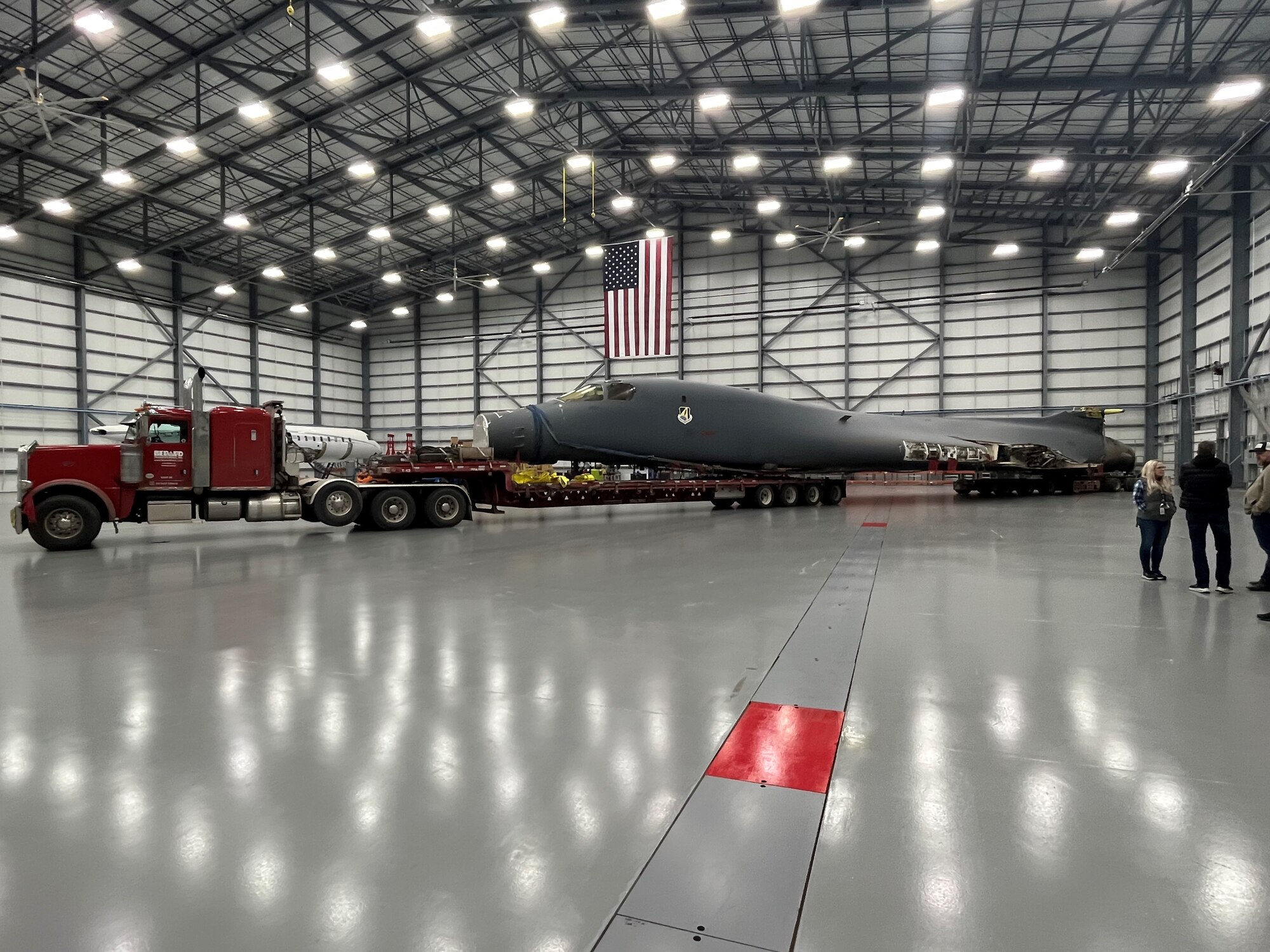 A B-1B Lancer stops in its final destination inside a hangar at Wichita State University’s National Institute for Aviation Research in Wichita, Kansas, after making a four-day road trip from Dyess Air Force Base, Texas, Jan. 27, 2024. The bomber will be used to create a digital twin, which will allow for greater study and potential improvements of the B-1 fleet. The B-1 is one of several airframes being examined and virtually mapped to create digital twins, as part of a partnership with NIAR and the Air Force Life Cycle Management Center.  (Courtesy Photo)