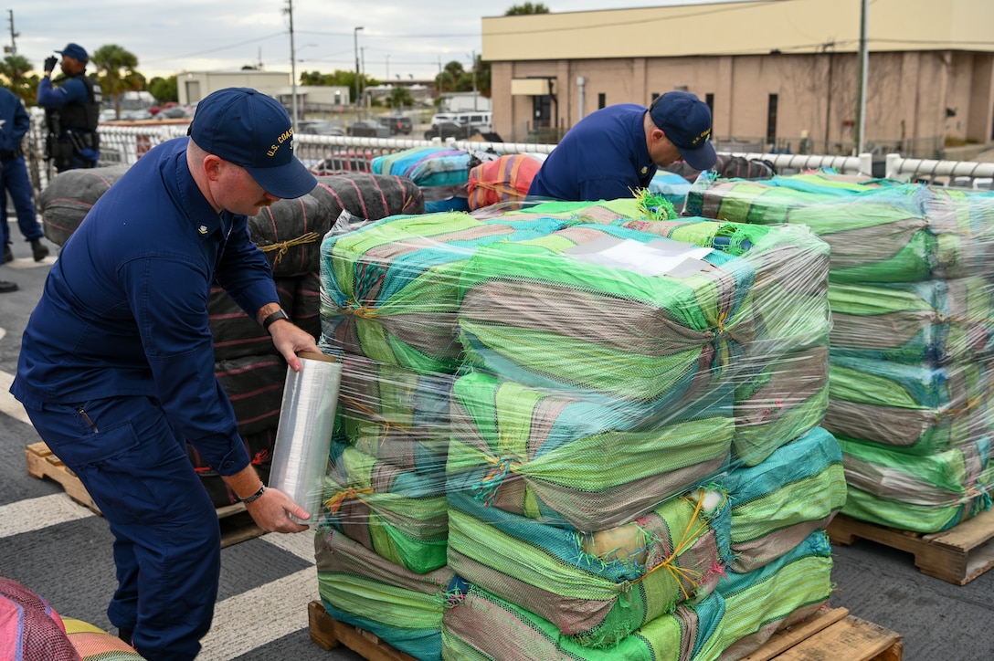Crew of Coast Guard Cutter Resolute saran wrap illegal narcotics on the helicopter deck, Jan. 29, 2024, in St. Petersburg, FL. The drugs, once secured, are offloaded from the cutter and given to partner agencies for destruction. (U.S. Coast Guard photo by Petty Officer 3rd Class Nicholas Strasburg)