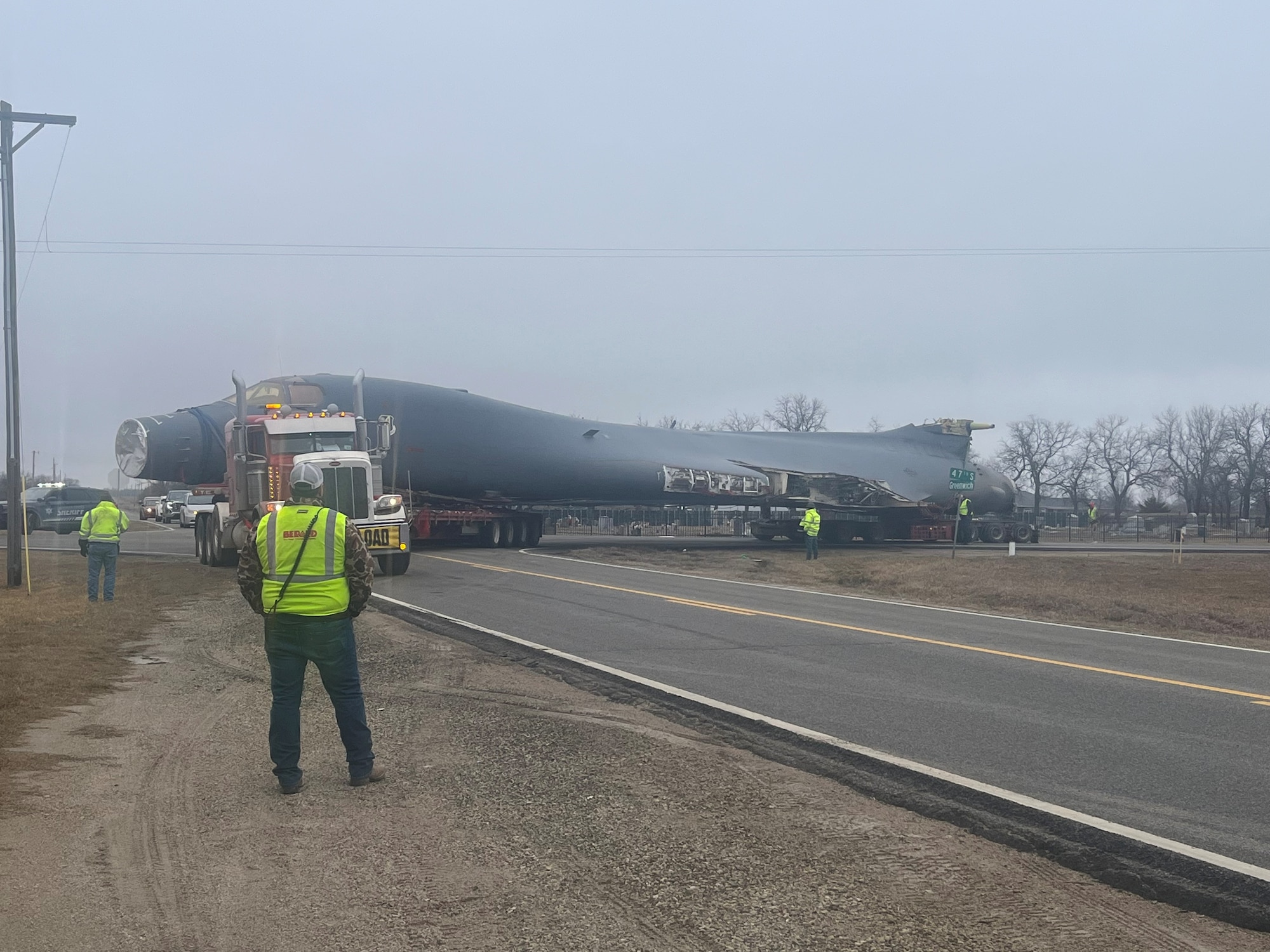 Contract crews along with Sedgwick County Sheriff’s Office deputies control traffic as a B-1B Lancer makes a tight turn at 47th Street South and Greenwich Road in Wichita, Kansas, Jan. 27, 2024. The bomber was bound from Dyess Air Force Base, Texas, to Wichita State University’s National Institute for Aviation Research to be used in a research partnership with WSU and the Air Force Lifecycle Management Center. The bomber will be used to create a digital twin, which will allow for greater study and potential improvements of the B-1 fleet. (Courtesy Photo)