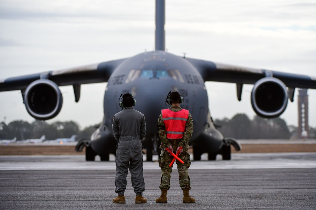 A photo of Airmen preparing to marshal a jet.