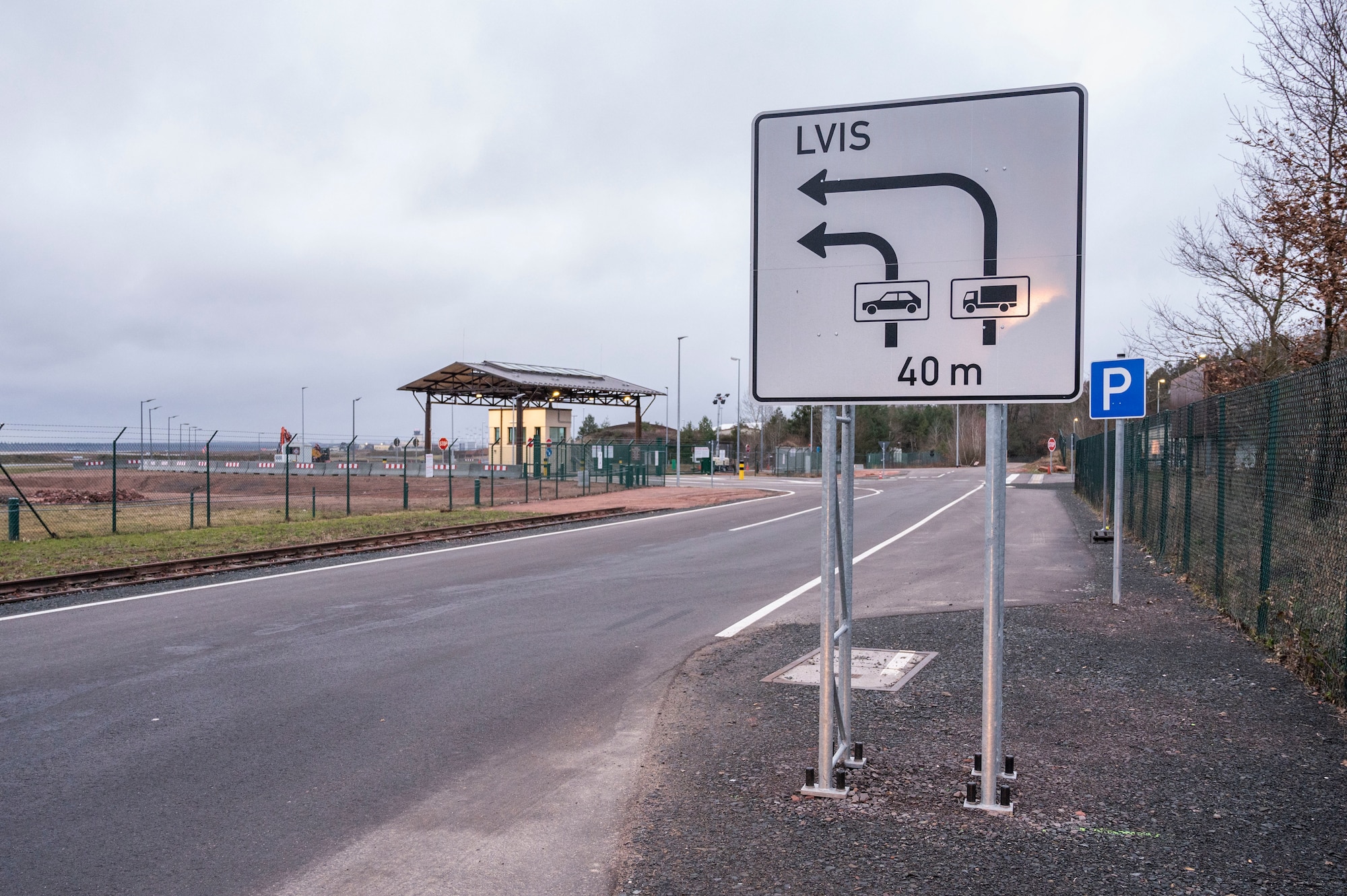 Picture shows a sign in front of a military base gate