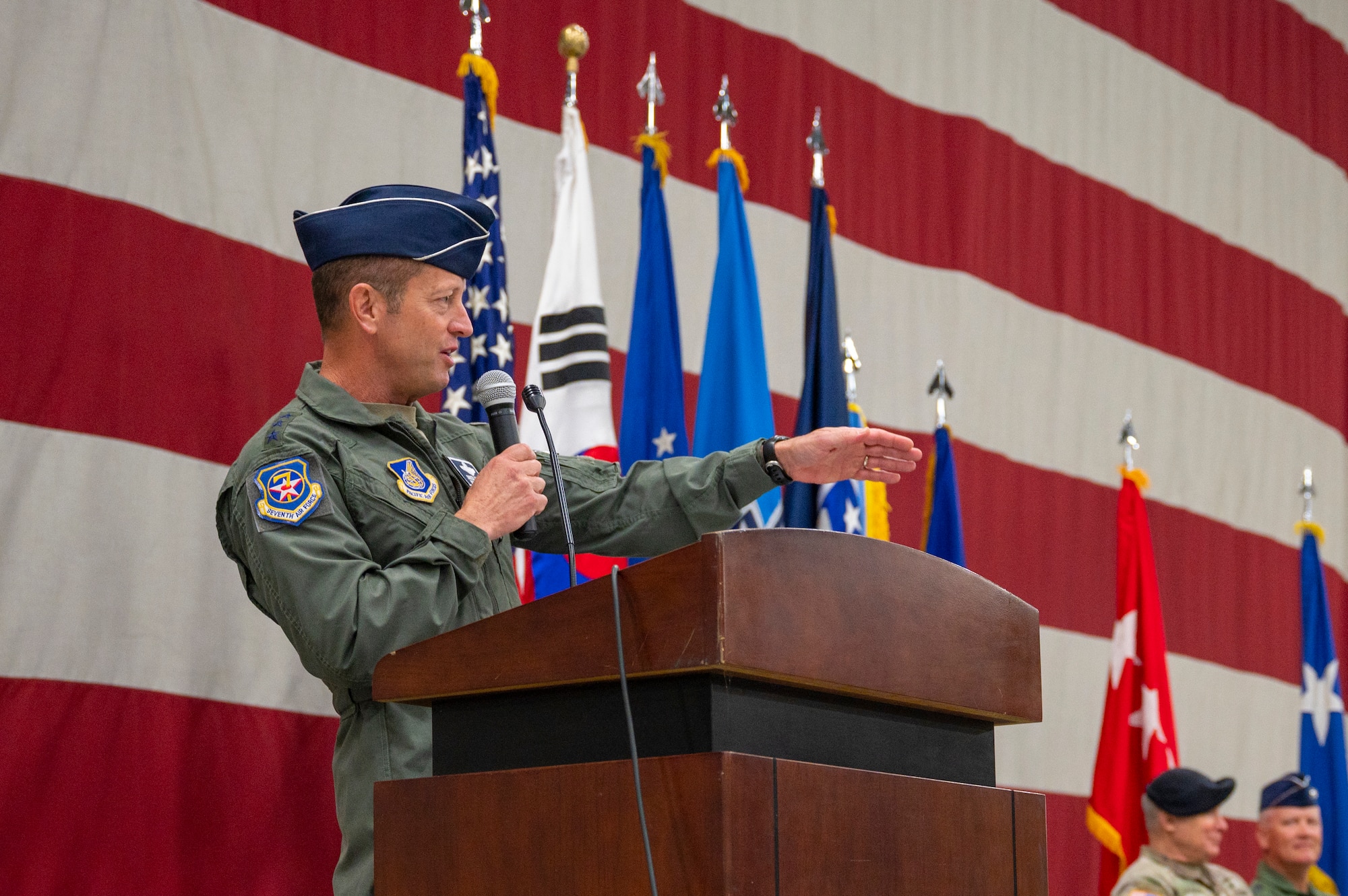 U.S. Air Force Lt. Gen. David Iverson gestures while speaking behind a podium during the Seventh Air Force change of command ceremony, at Osan Air Base, Republic of Korea.