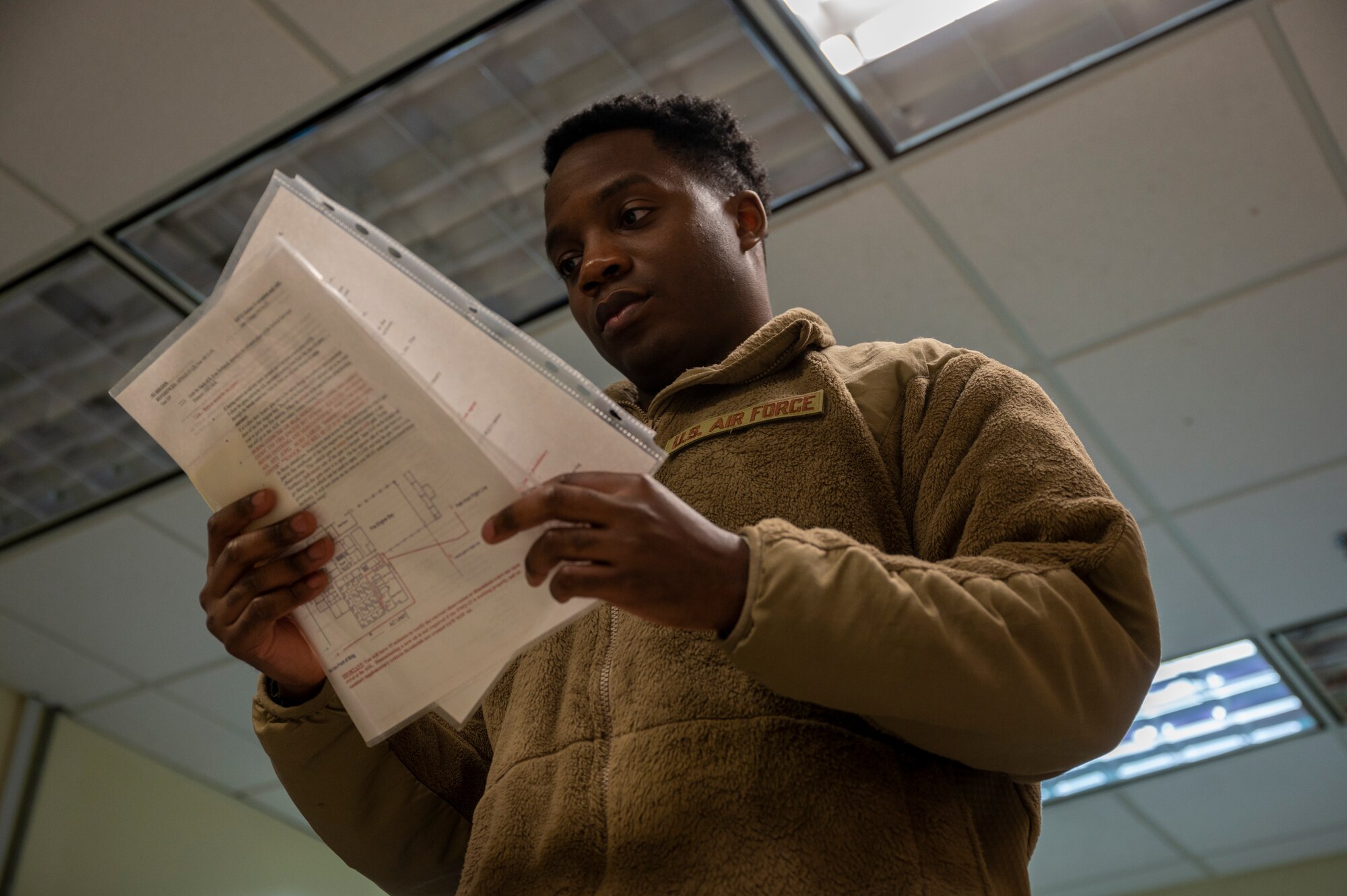 U.S. Air Force Staff Sgt. Jabari Freeman, 51st Operations Support Squadron weather technician, looks over a checklist to verify all procedures were followed after a simulated cyberattack during Beverly Midnight 24-1 at Osan Air Base, Republic of Korea, Jan. 29, 2024. The 51st OSS Airmen practiced relocating to train using available resources to maintain operational readiness. BM24-1 is a routine training event that tests the military capabilities across the peninsula, allowing combined and joint training at both the operational and tactical levels. (U.S. Air Force photo by Senior Airman Kaitlin Castillo)