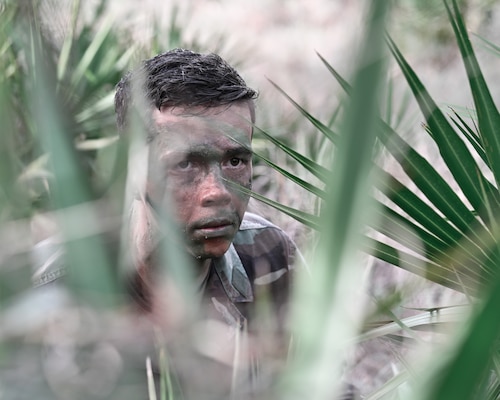 Lt. Jacob Westerberg, research psychologist for the Robert E. Mitchell Center (REMC) RPOW studies, dons the uniform and camouflage face-paint to re-enact scenes from his training and describe his professional take on psychological experiences faced by those having to endure real-life survival scenarios like those taught in the survive evade resist and escape (SERE) training. Photos were captured onboard Naval Air Station Pensacola, Jan. 11. The Robert E. Mitchell Center houses the POW research studies program for all branches the armed forces and has been an active program for 50 years as of 2023. (U.S. Navy photo by Mass Communication Specialist 1st Class Russell Lindsey SW/AW),