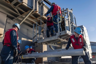 Sailors unload RIM 116 Block missiles from a rolling airframe missile launcher aboard USS Abraham Lincoln (CVN 72).