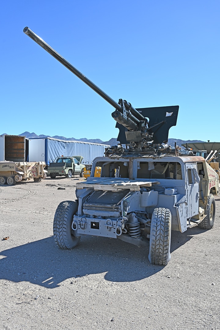 A fabricated vehicle with a large howitzer gun attached to the roof.