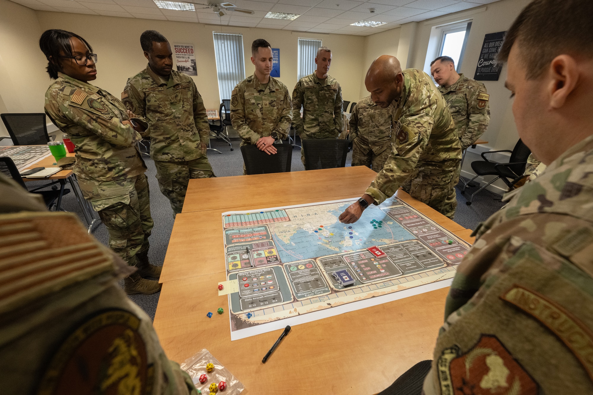 U.S. Airmen assigned to the 100th Air Refueling Wing participating in the Kingfish Agile Combat Employment tabletop gather to discuss their strategies at Royal Air Force Mildenhall, England, Jan. 22, 2024.