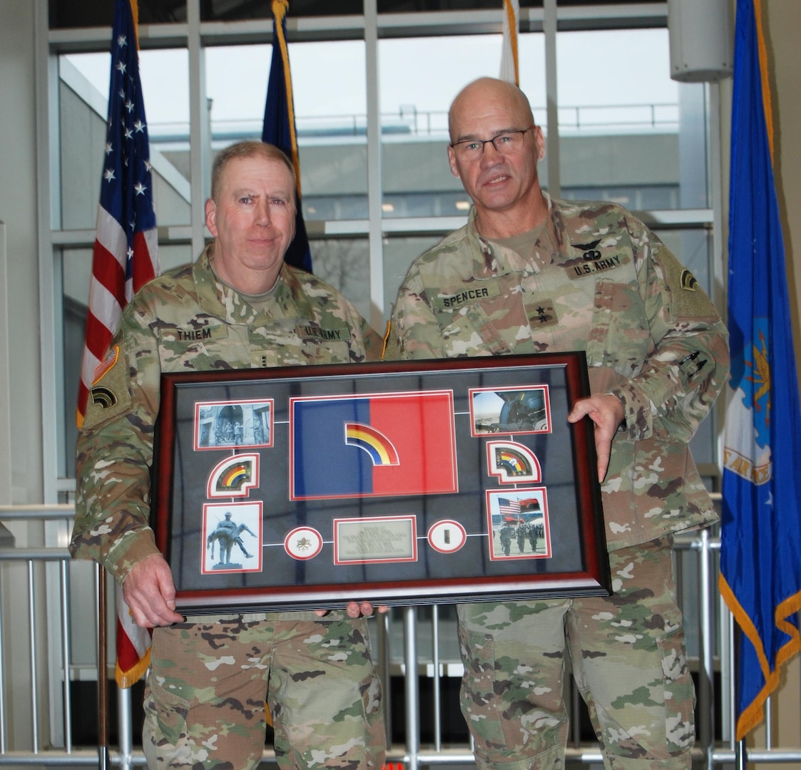 New York Army National Guard Chief Warrant Officer 4 Albert Thiem, left, who also served as a sergeant and a lieutenant colonel, receives a retirement gift from Maj. Gen. Thomas Spenser during a ceremony at New York National Guard headquarters in Latham, N.Y., Jan. 26, 2024.