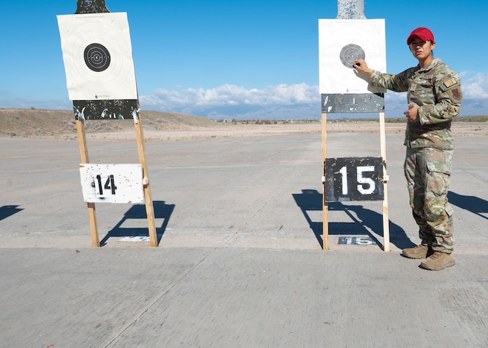 U.S. Air Force Staff Sergeant Vanessa Garcia, 355th Security Forces Squadron combat arms instructor, points to a target  during the Excellence in Competition at Davis-Monthan Air Force base, Ariz., Jan. 26, 2024. As a combat arms instructor and a line official for the EIC, Garcia ensured safety procedures were followed and graded targets. (U.S. Air Force photo by Airman 1st Class Robert Allen Cooke III)