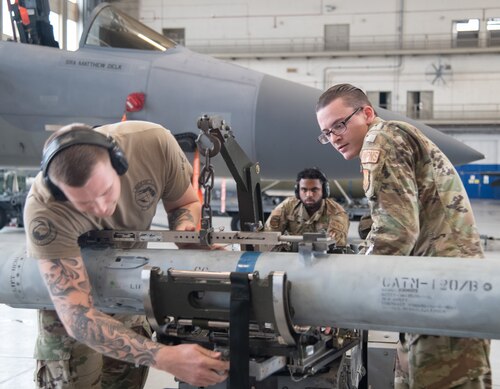 The 96th Aircraft Maintenance Squadron, Red team, weapons load crew work together to load the F-15 Eagle during the unit’s quarterly weapons load competition.