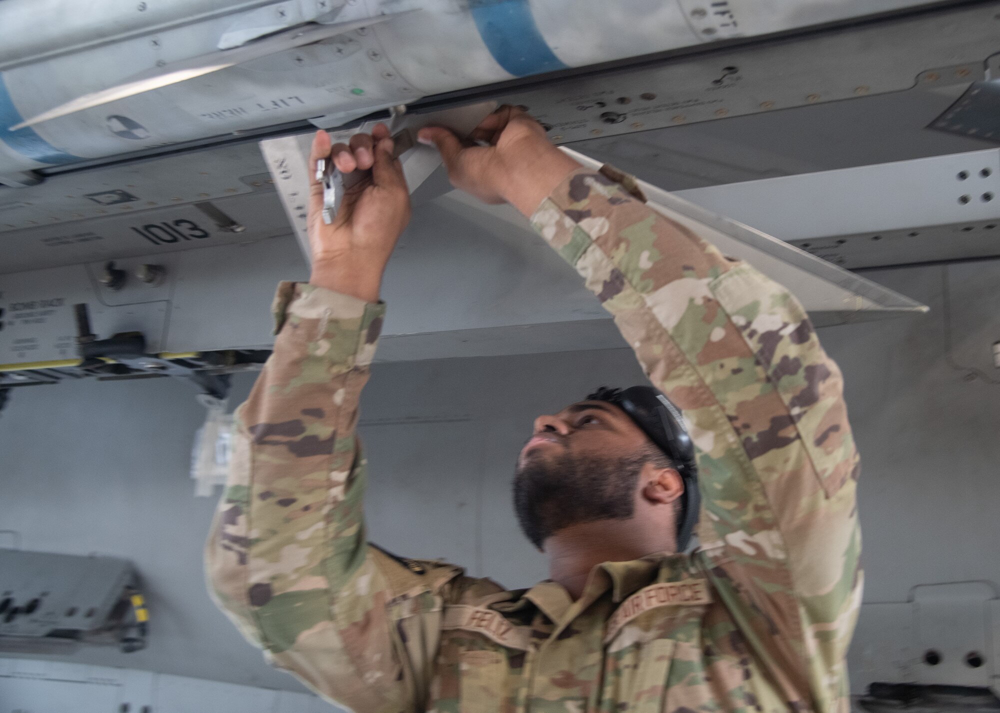 U.S. Air Force Senior Airman Ronald Feliz, 96th Aircraft Maintenance Squadron weapons load crew member, installs AIM-120 missile wings to an F-15 Eagle.