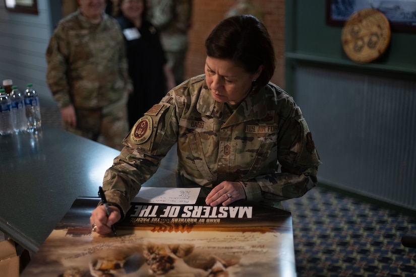 A military member signing a poster.