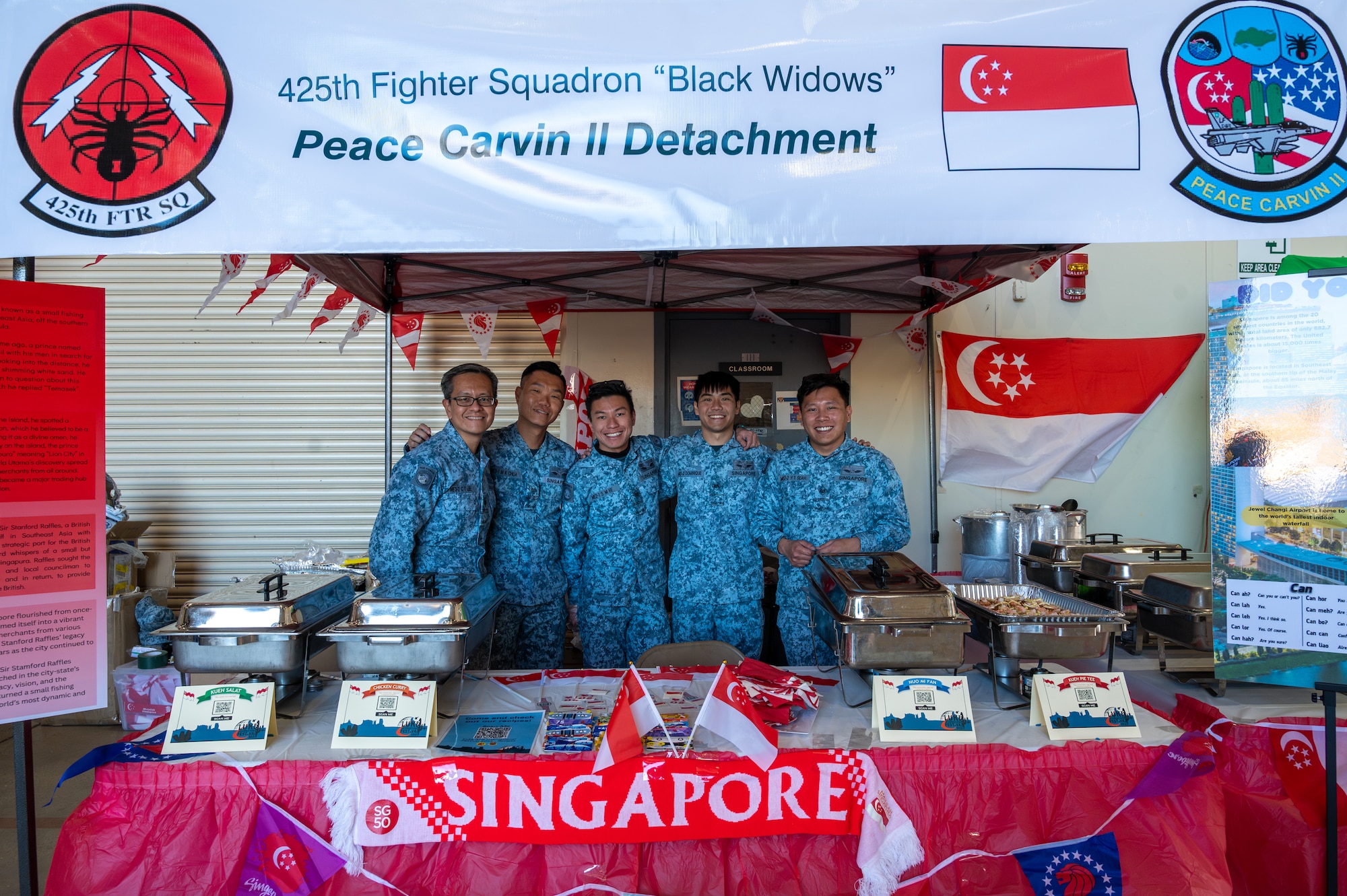 Members of Singapore’s Peace Carvin II Detachment assigned to the 425th Fighter Squadron post for a photo at a booth during the Luke Air Force Base International Festival 2024, Jan 26, 2024, at Luke AFB, Arizona.