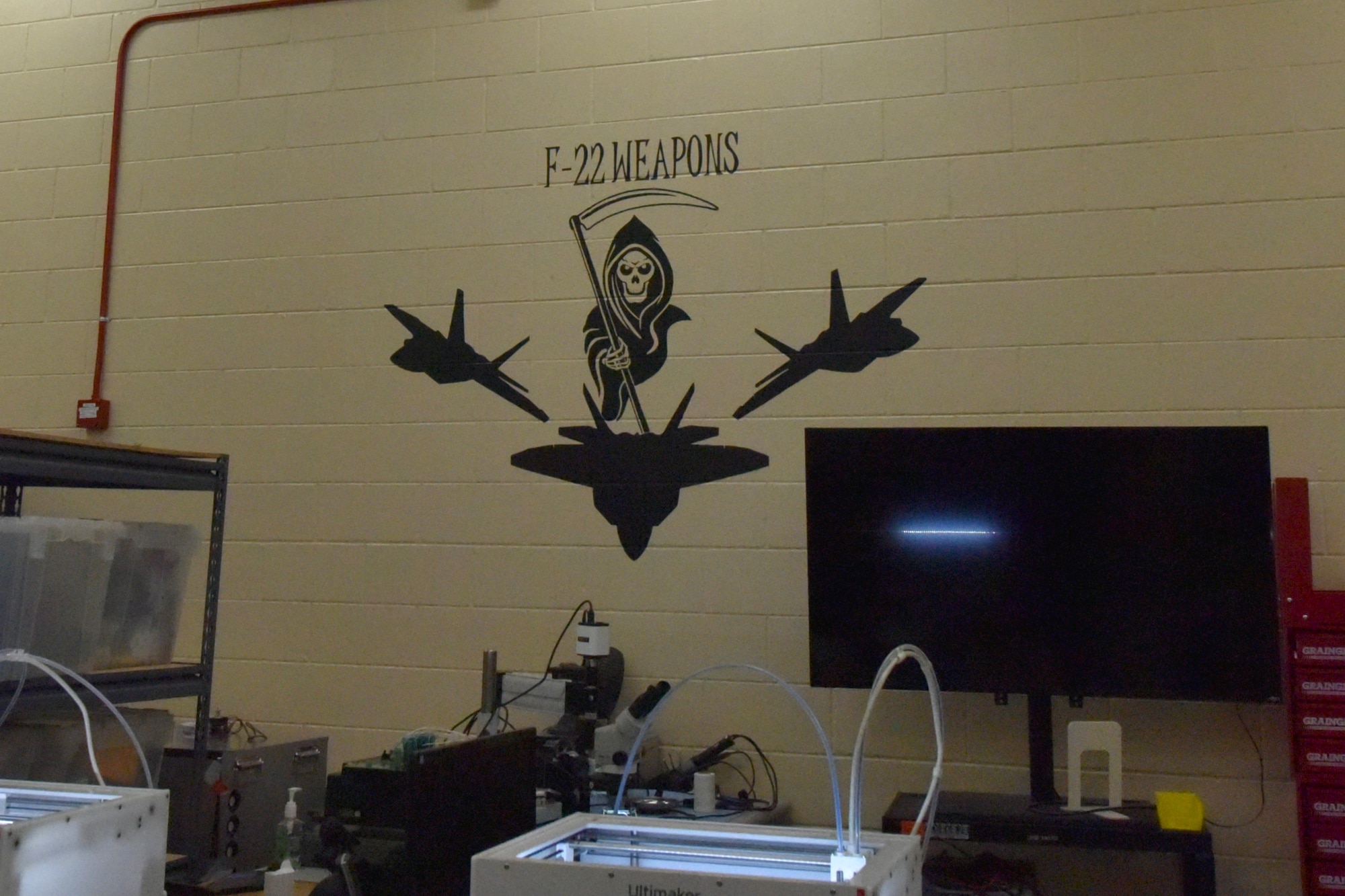 A yellow wall with a grim reaper and two F-22 jets painted on it