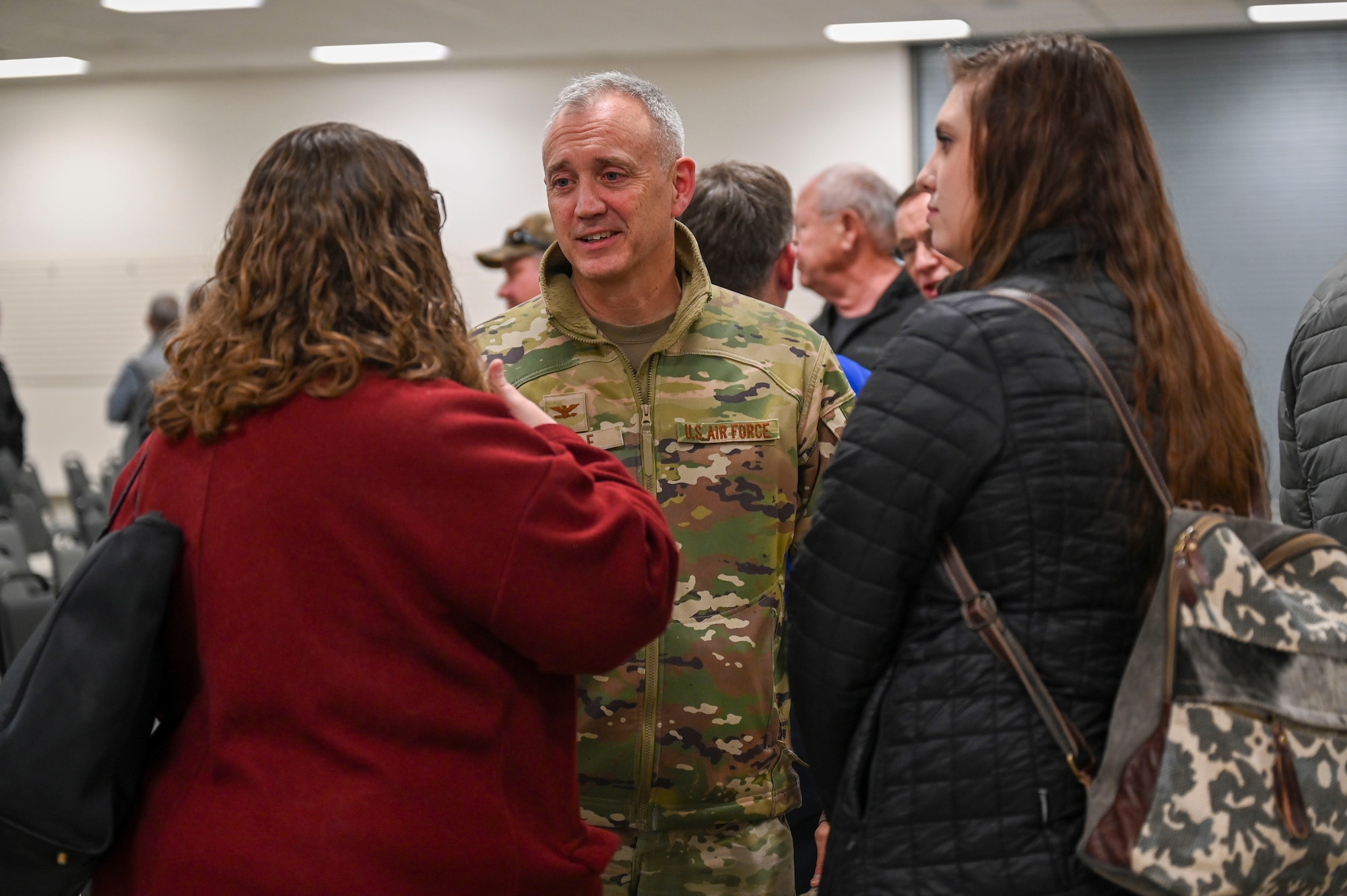 A man speaks with two women.