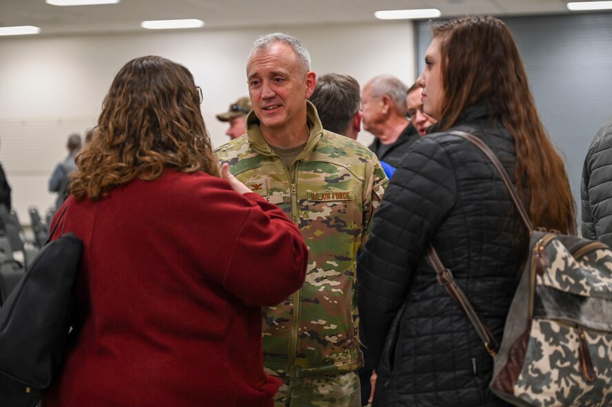 A man speaks with two women.