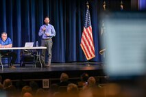 A man on stage speaking to a crowd