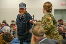 A woman hands a microphone to a man.