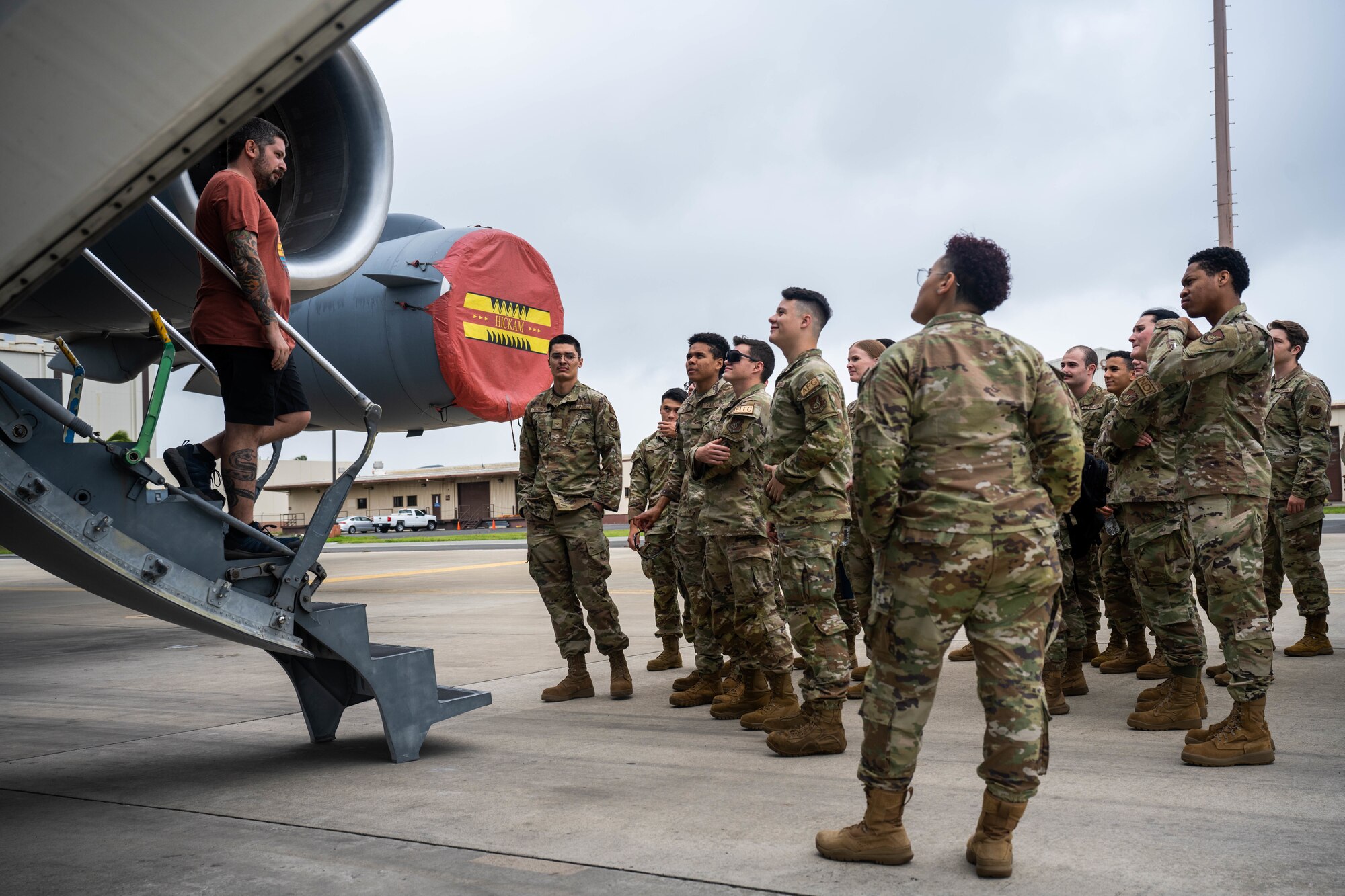 Airmen stand outside of airplane.