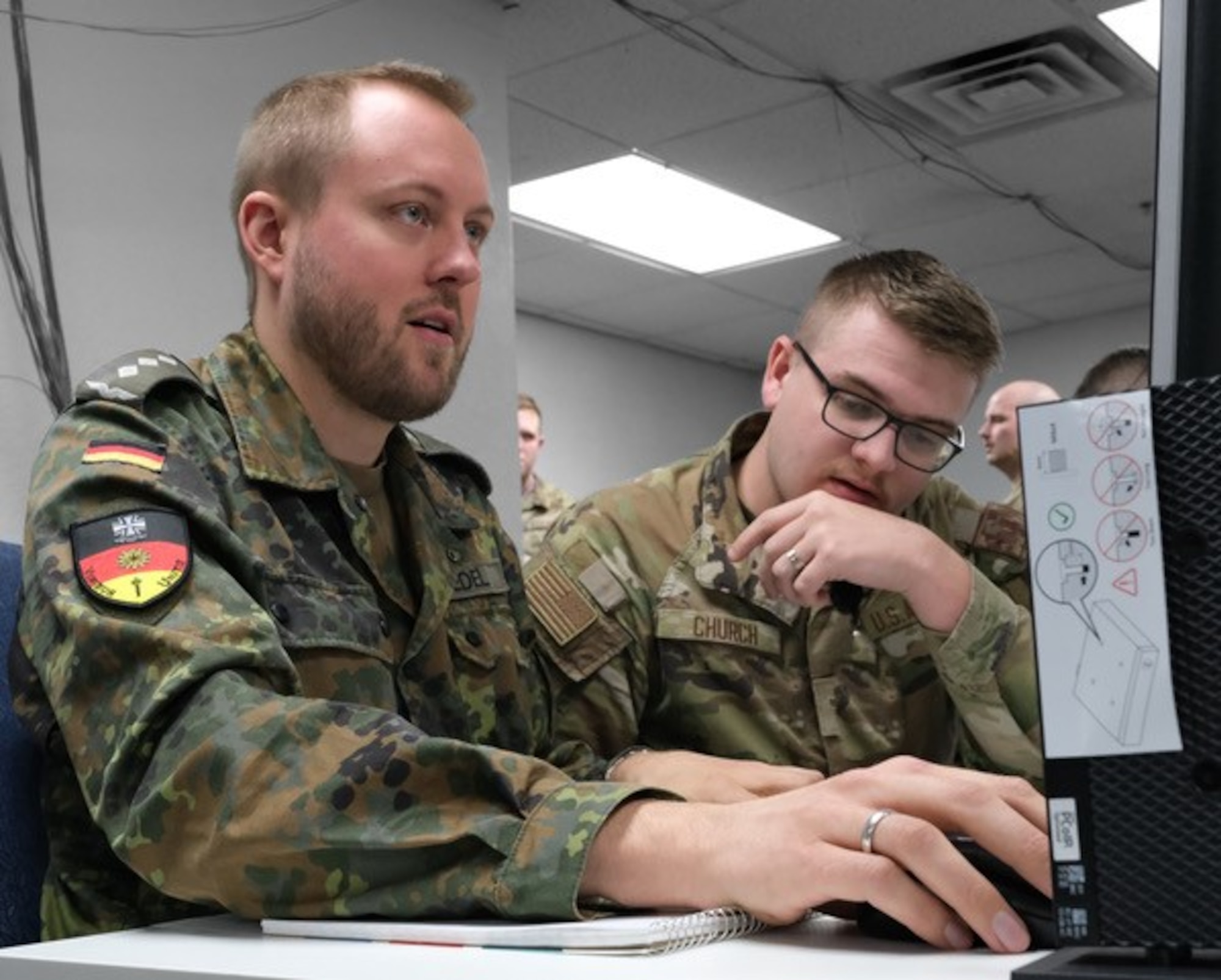 US and German military members work on computers