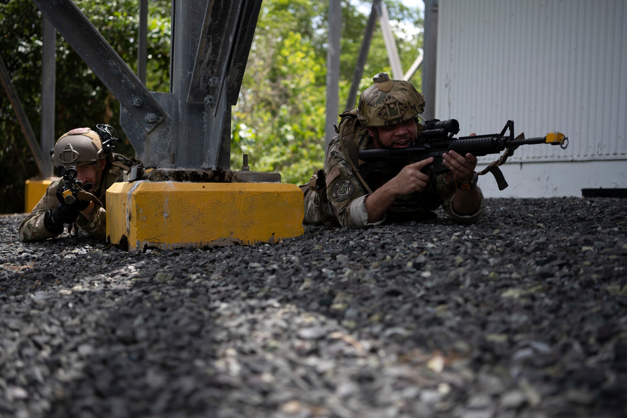 From left, U.S. Air Force Senior Airman Tyler McCauley, a security forces journeyman with the 123rd Contingency Response Group, Kentucky Air National Guard, and Senior Airman Kevin Medina, a security forces journeyman with the 156th Security Operations Squadron, Puerto Rico Air National Guard, engage opposing forces during air base ground defense training at Muñiz Air National Guard Base in Carolina, Puerto Rico, Sept. 21, 2023. During the training, Airmen reinforced air base ground defense skills utilized during contingency response operations in contested environments by practicing radio communications, warning and operation orders, vehicle searches, vehicle take-downs, close-quarter battle, and small team tactics. (U.S. Air National Guard photo by Master Sgt. Rafael D. Rosa)