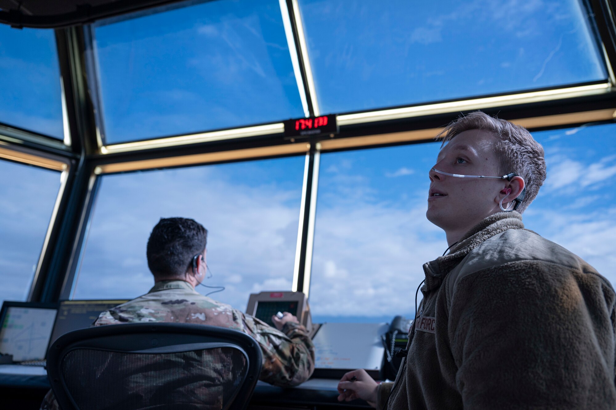 U.S. Air Force Senior Airman Kitt Kinsley (right), 54th Operations Support Squadron air traffic controller trainer, monitors aircraft movement on the flight line at Holloman Air Force Base, New Mexico, Jan. 24, 2024. ATC’s transmit and listen to multiple frequencies at one time and are responsible for separating and directing aircraft movement during all flightline operations. (U.S. Air Force photo by Airman 1st Class Michelle Ferrari)