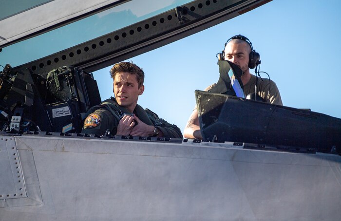 U.S. Air Force 1st Lt. Jake Heydinger, a pilot with the 525th Expeditionary Fighter Squadron, Joint Base Elmendorf-Richardson, Alaska, and U.S. Air Force Airman First Class Jacob Upton, an assistant dedicated crew chief with the 525th Expeditionary Fighter Generation Squadron, watch an aircraft launch prior to flight in support of Exercise Bamboo Eagle 24-1 at Nellis Air Force Base, Nevada, Jan. 25, 2024.