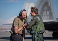 U.S. Air Force Airman First Class Jacob Upton, an assistant dedicated crew chief with the 525th Expeditionary Fighter Generation Squadron, Joint Base Elmendorf-Richardson, Alaska, speaks with U.S. Air Force 1st Lt. Jake Heydinger, a pilot with the 525th Expeditionary Fighter Squadron, prior to flight in support of Exercise Bamboo Eagle 24-1 at Nellis Air Force Base, Nevada, Jan. 25, 2024.